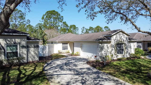 single story home with a garage, driveway, a front yard, and fence