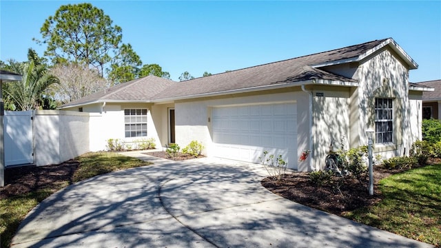 ranch-style house featuring stucco siding, a shingled roof, an attached garage, fence, and driveway