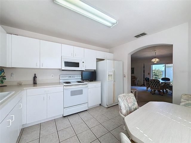 kitchen featuring white appliances, visible vents, white cabinets, arched walkways, and light countertops