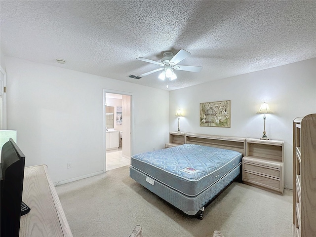 bedroom featuring visible vents, light carpet, and a textured ceiling