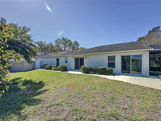 rear view of house with a patio area, fence, a lawn, and stucco siding