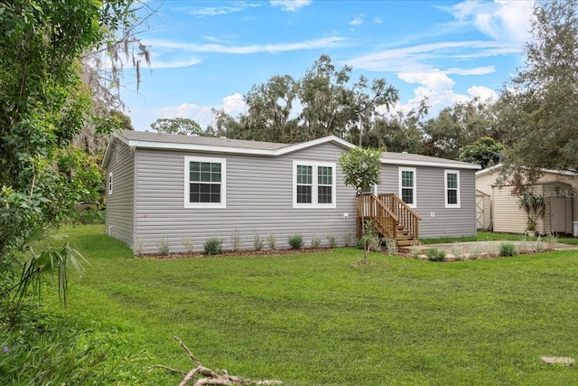 back of property with a yard and an outdoor structure