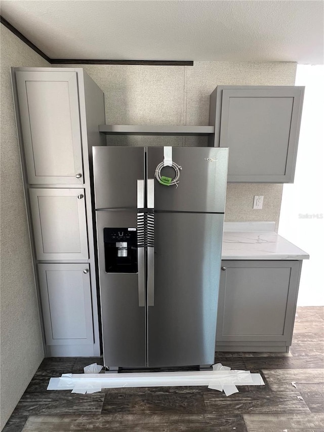 kitchen featuring gray cabinets, stainless steel fridge, and wood finished floors