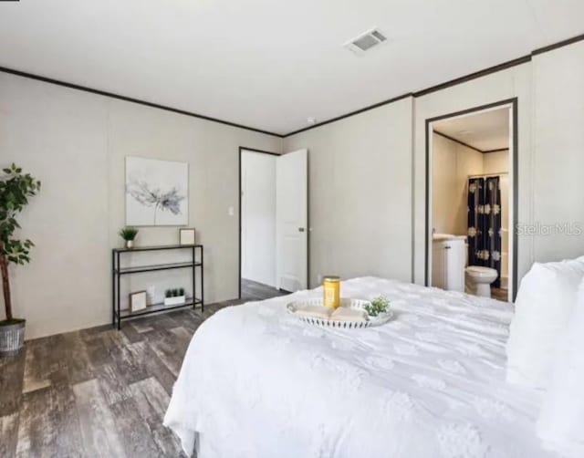 bedroom featuring ornamental molding, wood finished floors, and visible vents