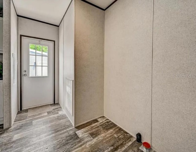 entryway featuring wood finished floors and crown molding