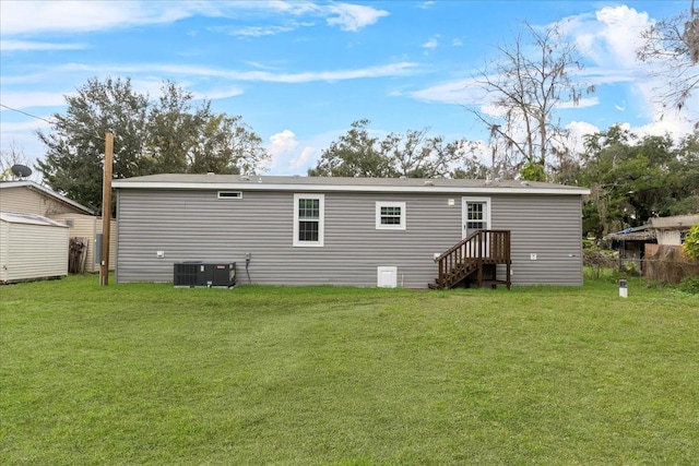 back of house with cooling unit, a yard, an outdoor structure, and fence