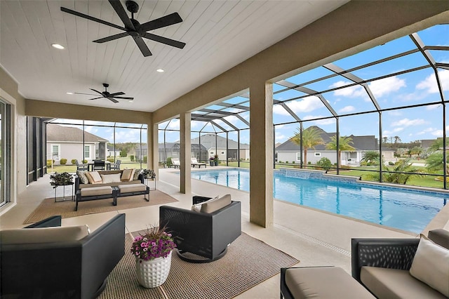 outdoor pool with a patio area, a residential view, glass enclosure, and an outdoor living space