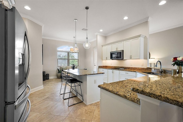 kitchen featuring dark stone counters, a kitchen island, stainless steel appliances, white cabinetry, and a sink