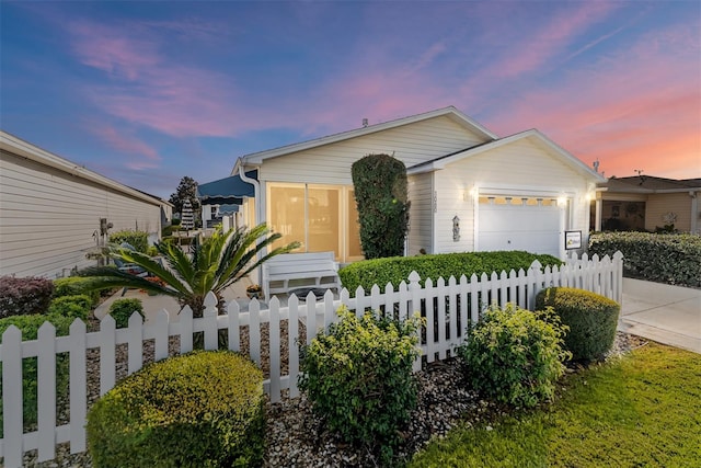 ranch-style house with a fenced front yard and an attached garage