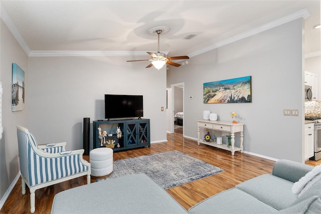 living room featuring baseboards, wood finished floors, visible vents, and ornamental molding