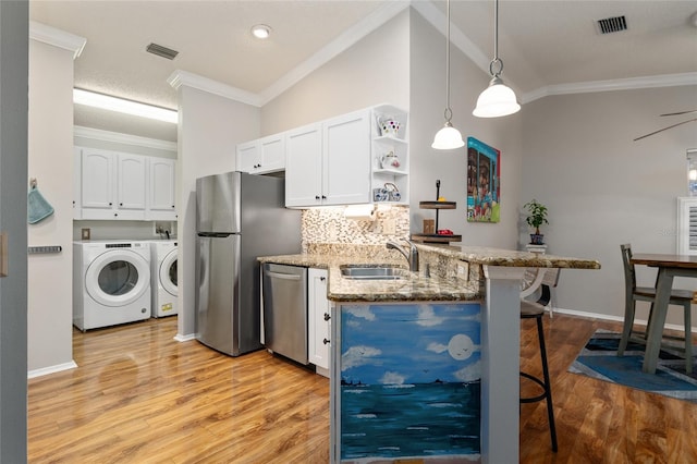 kitchen featuring a sink, a kitchen bar, appliances with stainless steel finishes, white cabinetry, and open shelves