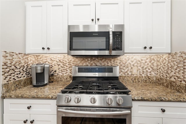 kitchen featuring tasteful backsplash, white cabinets, appliances with stainless steel finishes, and light stone counters