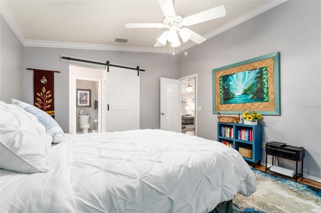 bedroom with visible vents, a ceiling fan, wood finished floors, a barn door, and crown molding