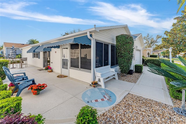 back of house featuring a patio area and a sunroom