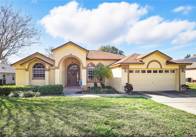 mediterranean / spanish-style house featuring a garage, a front yard, concrete driveway, and stucco siding