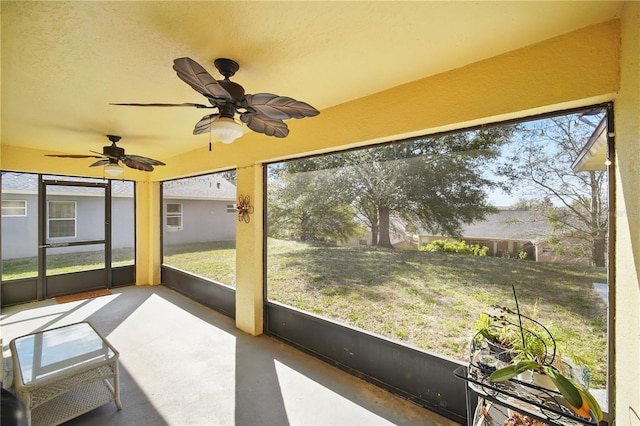 unfurnished sunroom with a ceiling fan