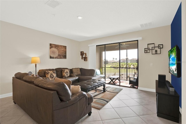 living area with light tile patterned floors, visible vents, and baseboards