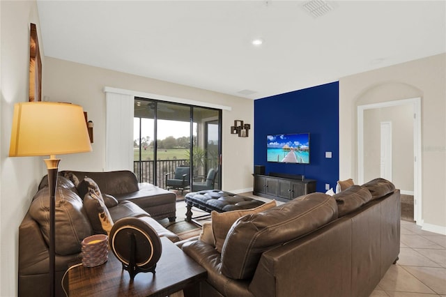 living area with light tile patterned floors, visible vents, and baseboards