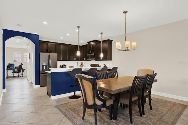 dining space featuring arched walkways, light tile patterned floors, recessed lighting, visible vents, and a chandelier