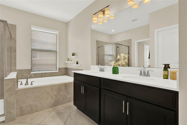 full bathroom with tile patterned flooring, a garden tub, a sink, and a shower stall