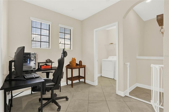 office area featuring arched walkways, washer / clothes dryer, baseboards, and light tile patterned floors