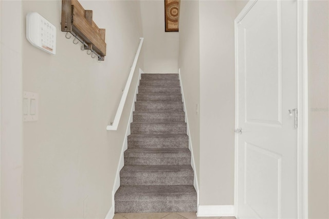 stairs featuring tile patterned flooring and baseboards