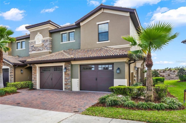 view of front of home featuring stone siding, decorative driveway, a garage, and stucco siding