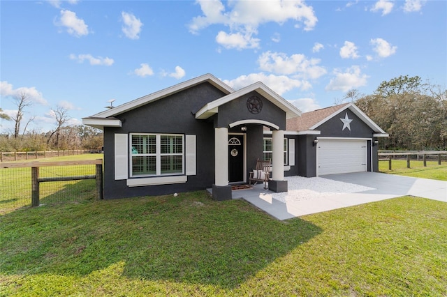 ranch-style home with an attached garage, fence, driveway, stucco siding, and a front lawn