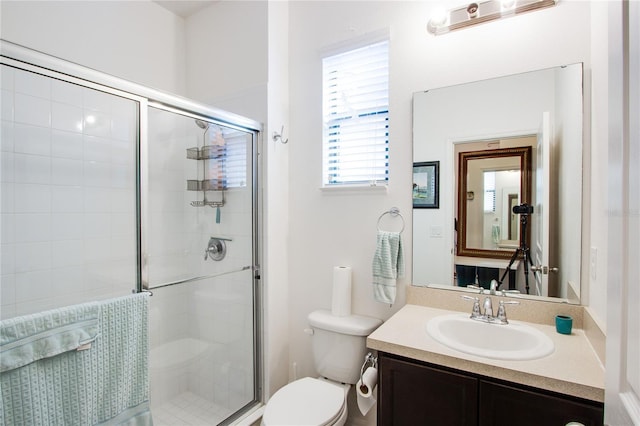 full bathroom featuring vanity, a shower stall, and toilet