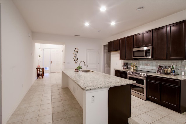 kitchen with a sink, stainless steel appliances, tasteful backsplash, and light tile patterned flooring