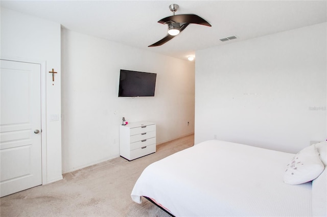 bedroom featuring visible vents, light colored carpet, and a ceiling fan