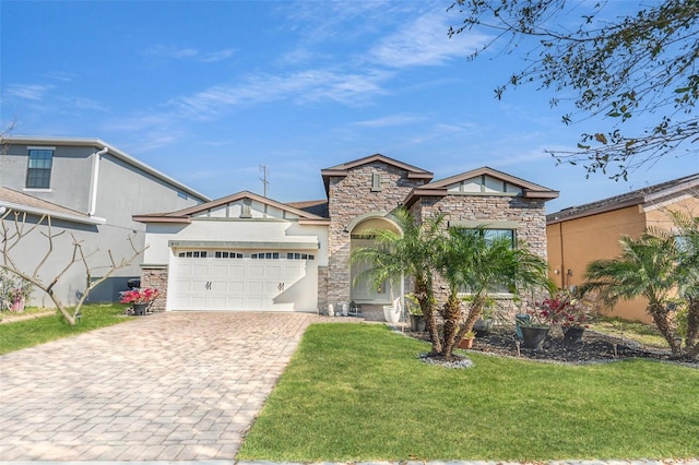 view of front of house featuring stucco siding, a front lawn, decorative driveway, stone siding, and an attached garage