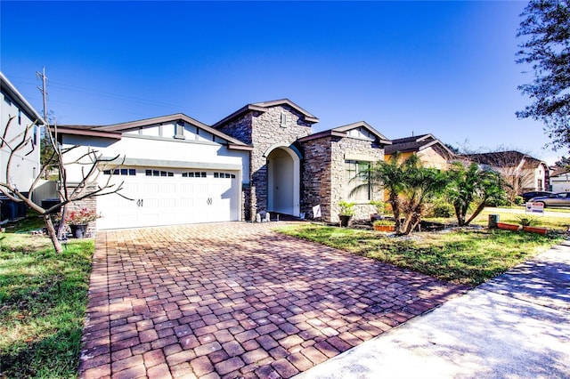 view of front facade with stone siding, a garage, and decorative driveway