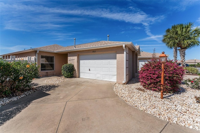 ranch-style house with concrete driveway, a shingled roof, an attached garage, and stucco siding