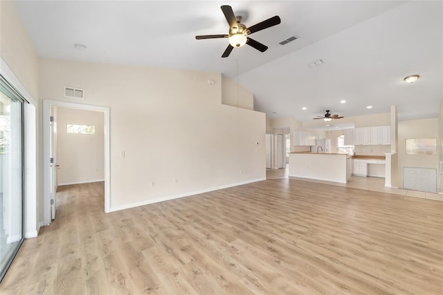 unfurnished living room featuring light wood-style floors, lofted ceiling, and visible vents