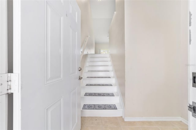 staircase featuring baseboards and tile patterned floors