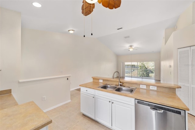 kitchen featuring lofted ceiling, a sink, white cabinetry, light countertops, and dishwasher