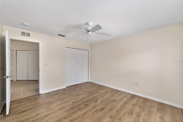 unfurnished bedroom with light wood finished floors, a closet, visible vents, and baseboards