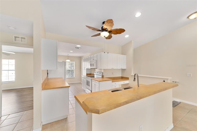 kitchen with white cabinets, white appliances, visible vents, and light tile patterned flooring