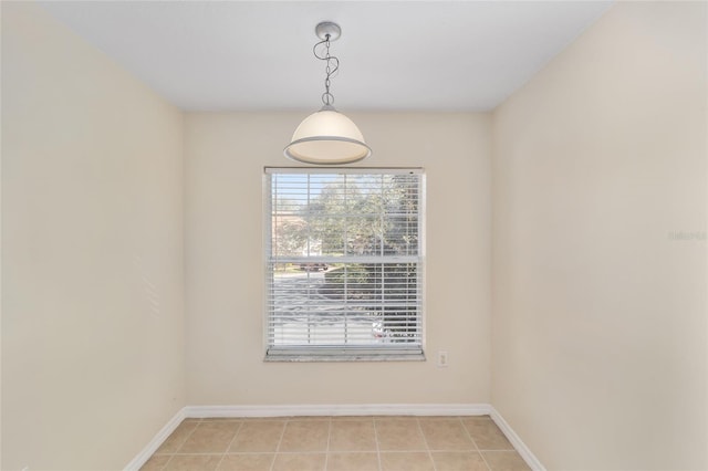 unfurnished room featuring baseboards and light tile patterned floors