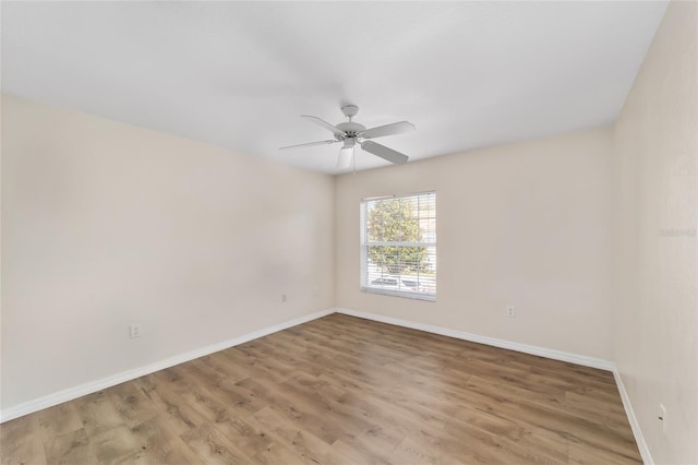 spare room featuring ceiling fan, light wood-style flooring, and baseboards