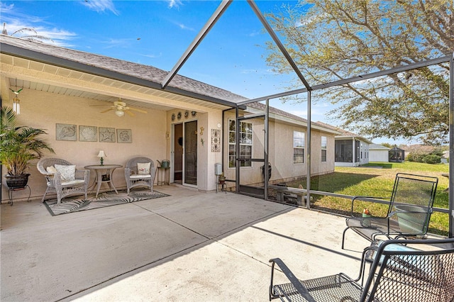 back of house with ceiling fan, a patio, a yard, and a lanai