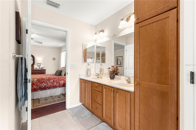 bathroom featuring ensuite bath, a sink, visible vents, and tile patterned floors