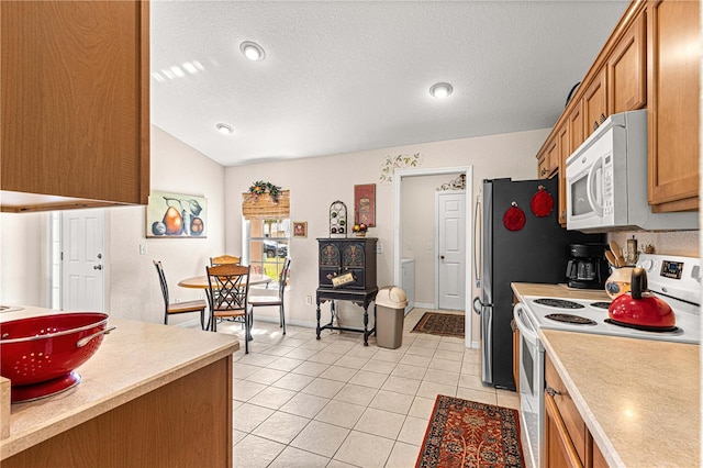 kitchen featuring light tile patterned floors, a textured ceiling, white appliances, light countertops, and brown cabinetry