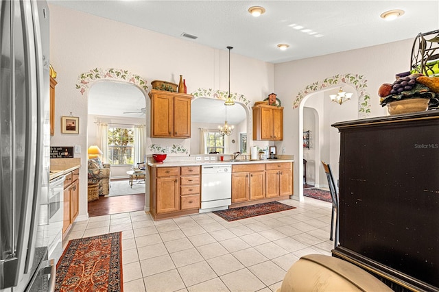 kitchen featuring arched walkways, light tile patterned floors, white appliances, visible vents, and light countertops