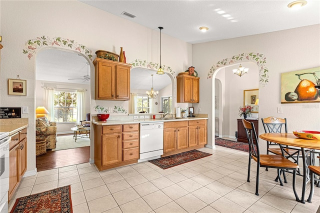 kitchen with visible vents, arched walkways, white dishwasher, light countertops, and light tile patterned flooring