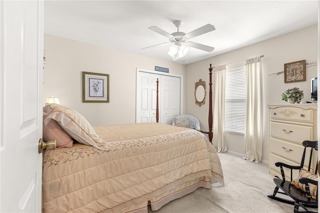 bedroom with a ceiling fan, a closet, light colored carpet, and baseboards