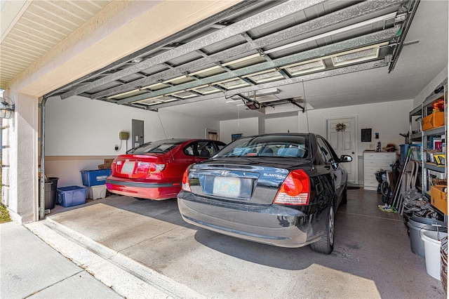 garage with electric panel and a garage door opener