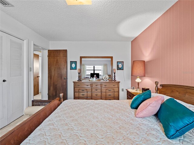 bedroom featuring a textured ceiling, a closet, and visible vents