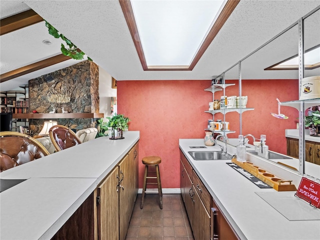 kitchen featuring a textured ceiling, light countertops, and a sink